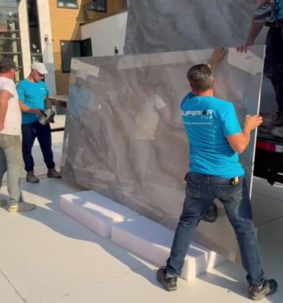 Superior Tile installers moving a large format tile panel